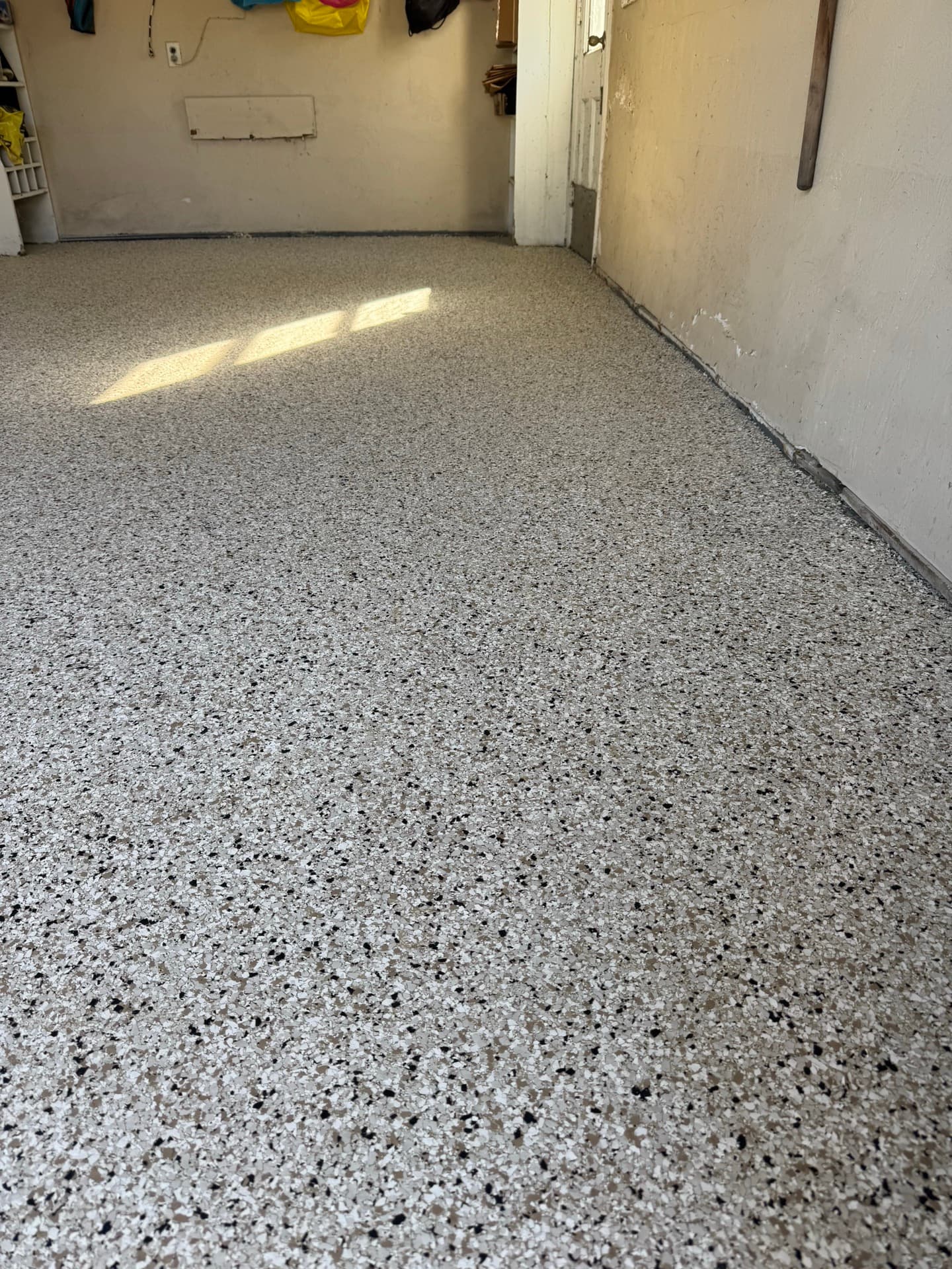 After: Gray flake polyurea coating on same garage wall and floor