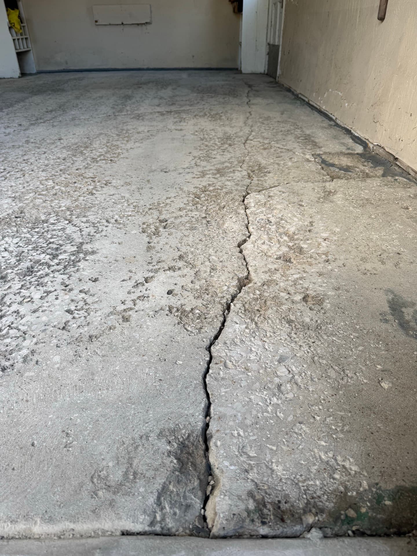 Before: Stained and cracked garage wall and floor