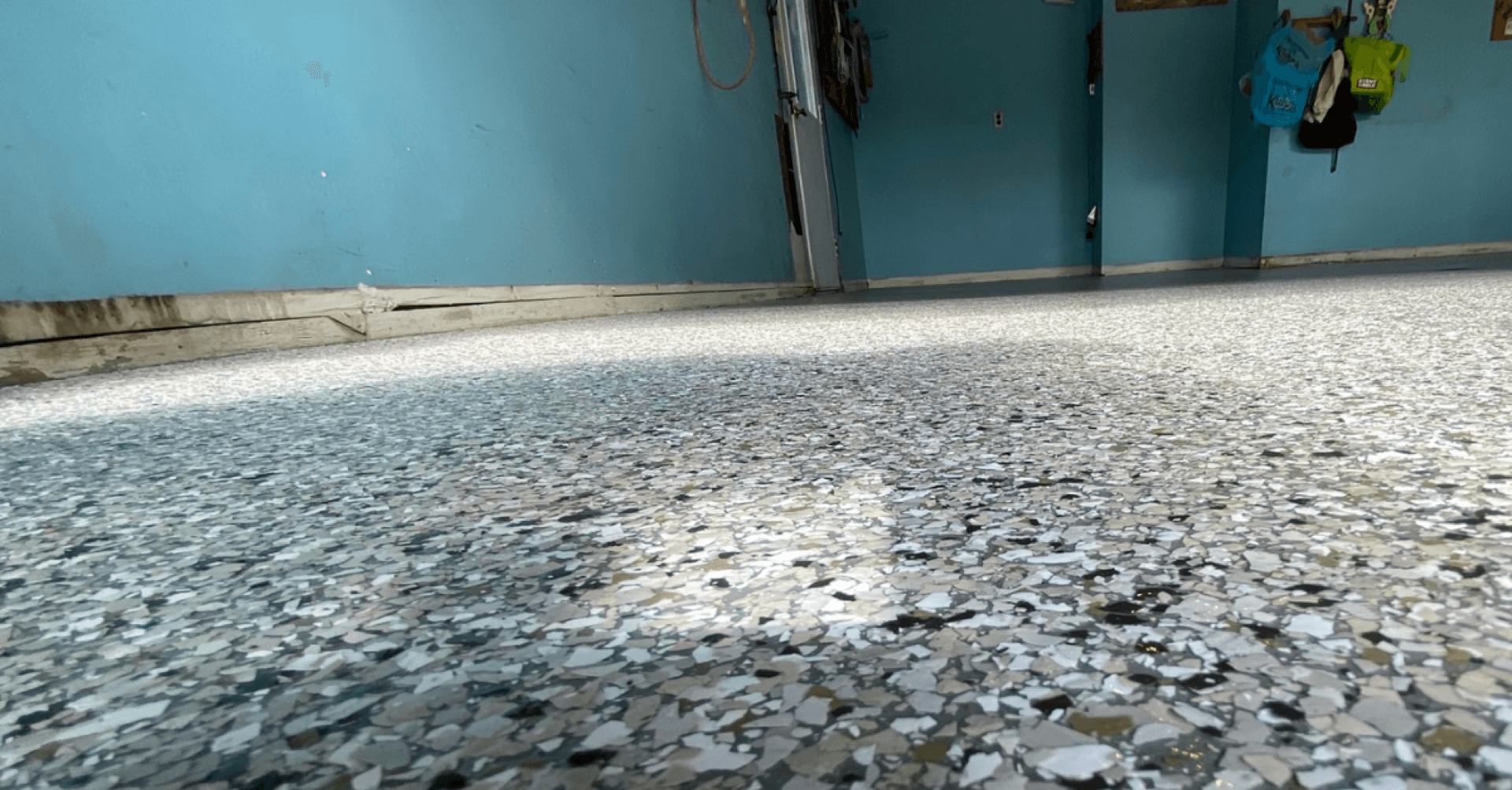 Gray flake polyurea garage floor with blue walls