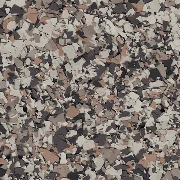 A close-up image of a textured surface featuring a scattering of beige, brown, and gray irregular pieces, creating a speckled pattern.