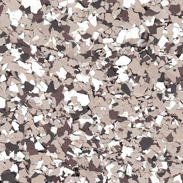 A textured surface with scattered, irregular tan, white, and brown flakes creating a camouflaged, mosaic-like pattern across the entire image.